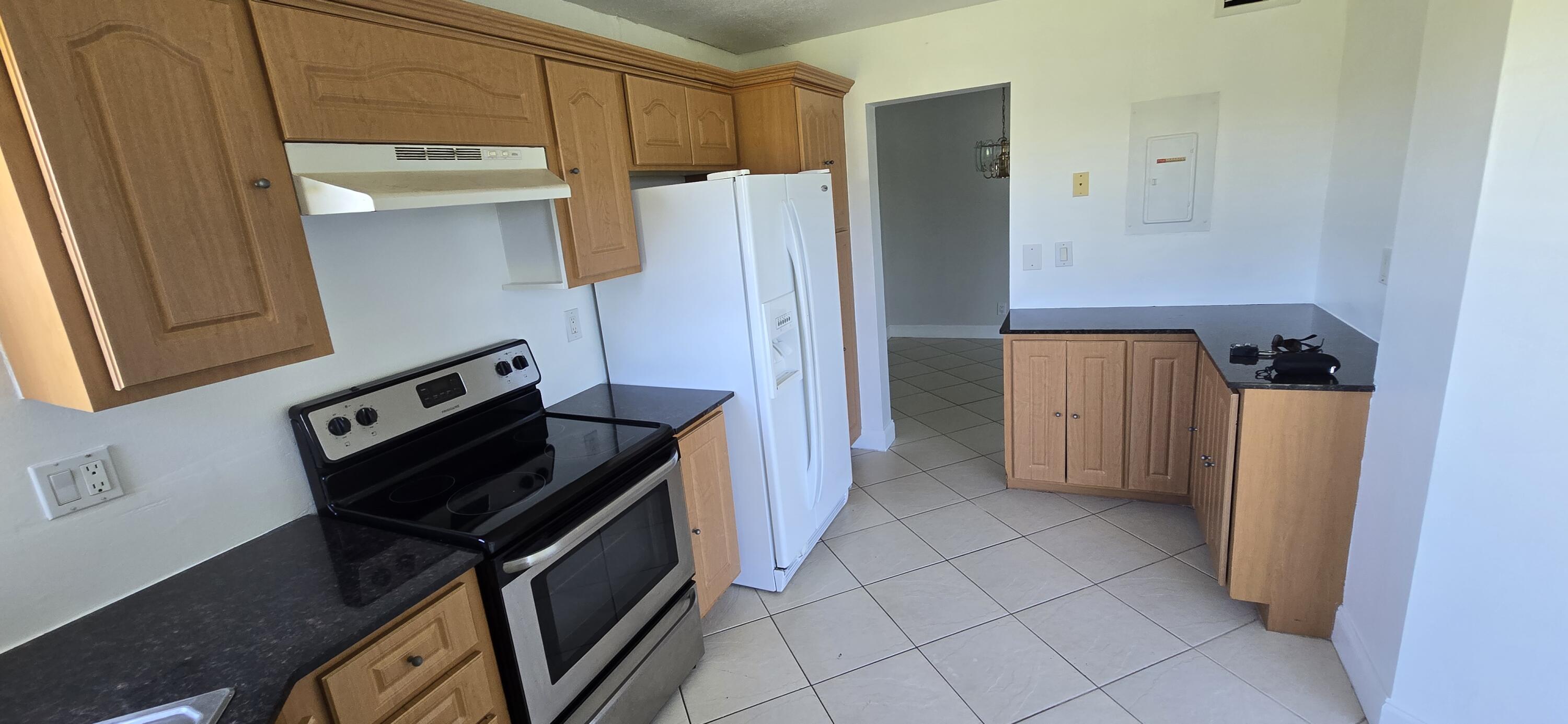 3661 Via Poinciana, Unit 306 Lake Worth, FL 33467 - Photo 7 of 13 a kitchen with a refrigerator and a stove