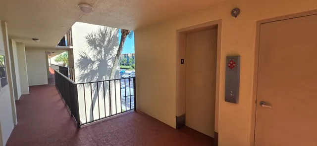 a view of a hallway with wooden floor and stairs