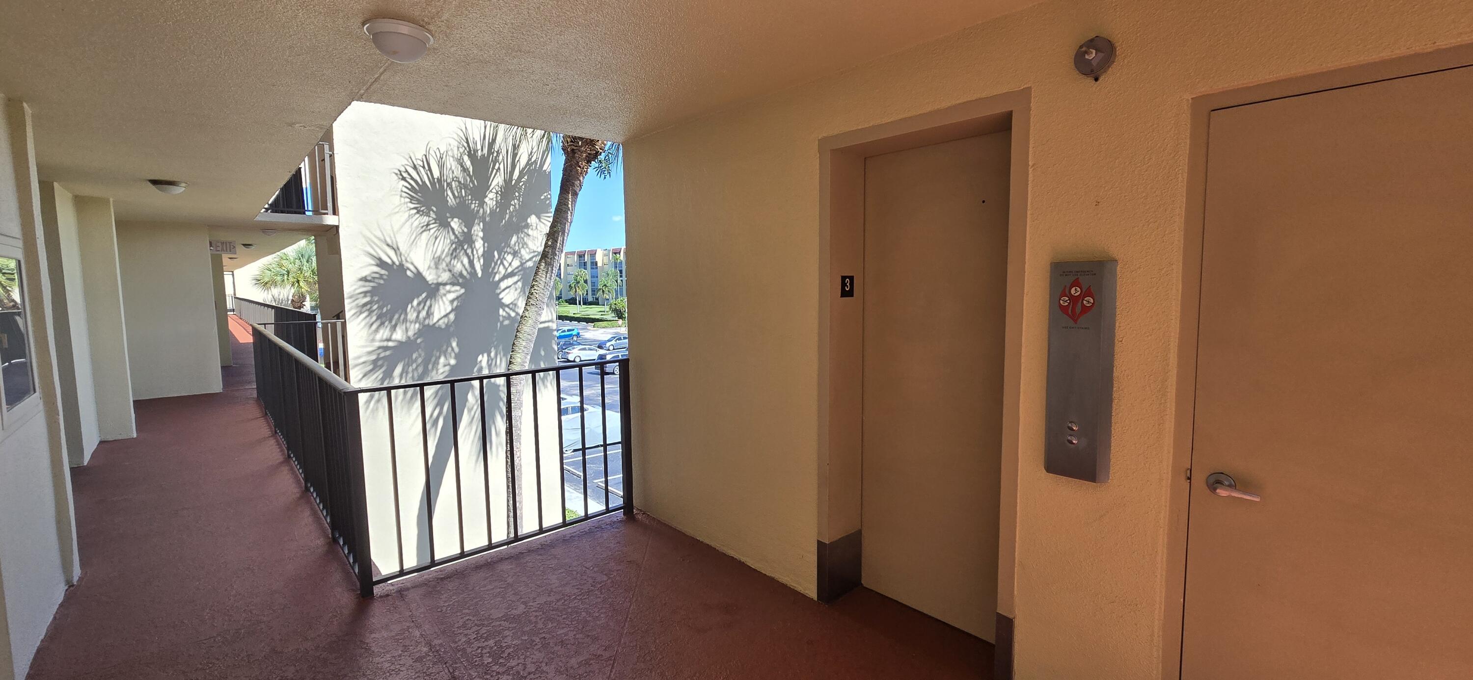 3661 Via Poinciana, Unit 306 Lake Worth, FL 33467 - Photo 10 of 13 a view of a hallway with wooden floor and stairs