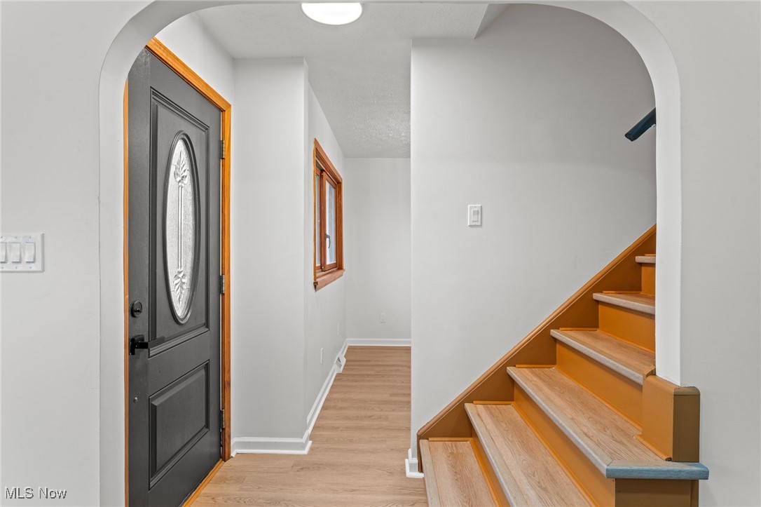 5266 Wilson Mills Road Cleveland, OH 44143 - Photo 2 of 50 Entryway with arched walkways, light wood finished floors, and stairs
