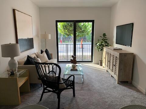 4290 Lakewood Road, Unit 101 Lake Worth, FL 33461 - Photo 6 of 13 a living room with furniture and a flat screen tv