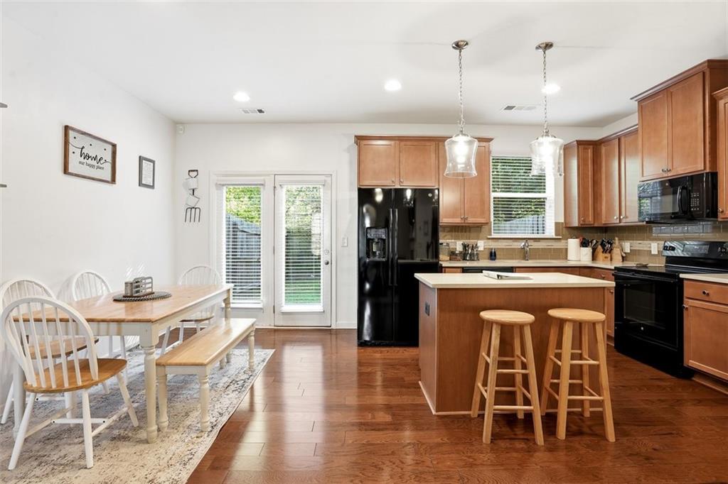 5026 Longview Walk Decatur, GA 30035 - Photo 8 of 31 a kitchen with stainless steel appliances granite countertop a stove a refrigerator a kitchen island with a dining table and chairs