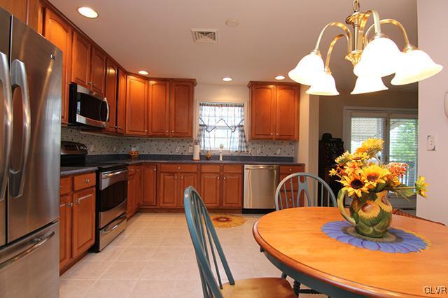 4144 Walter Road Bethlehem, PA 18020 - Photo 28 of 46 a kitchen with stainless steel appliances granite countertop a dining table chairs and a refrigerator