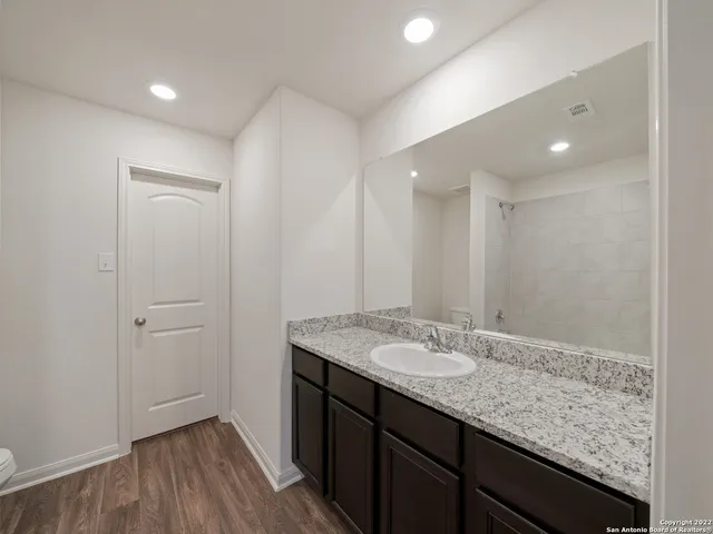 a bathroom with a granite countertop sink and a mirror