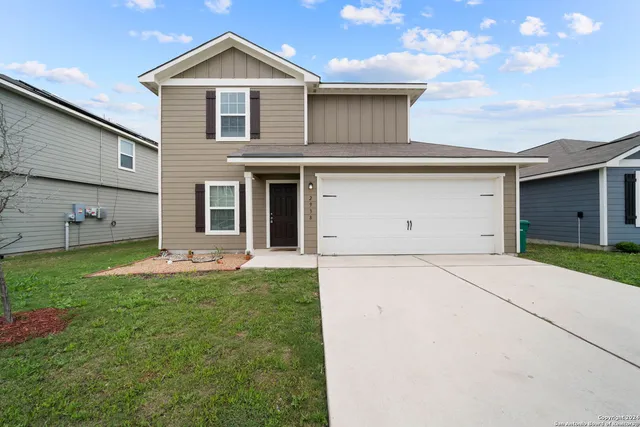 a front view of a house with a yard and garage