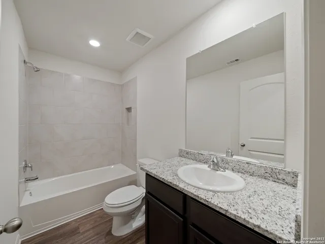 a bathroom with a granite countertop sink toilet and shower