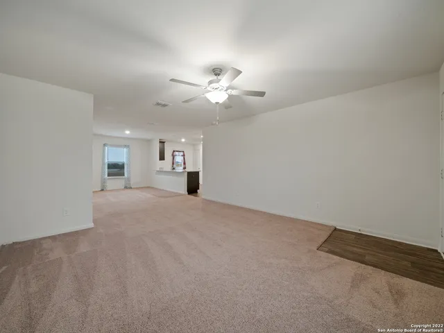 a view of a big room with chandelier fan and windows