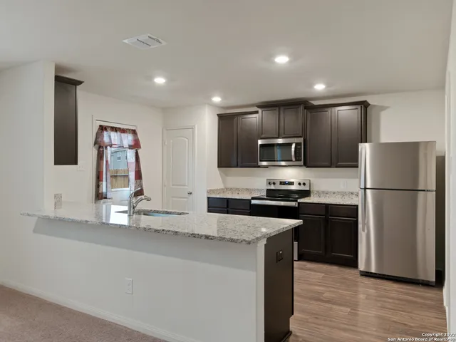 a kitchen with granite countertop stainless steel appliances and wooden cabinets