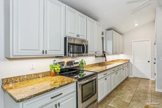 a kitchen with stainless steel appliances granite countertop a sink stove and cabinets