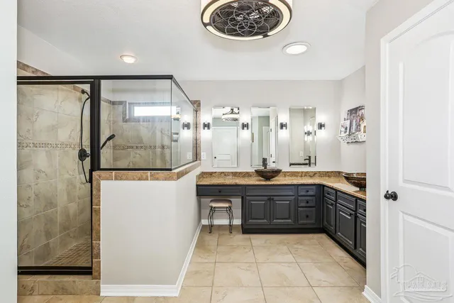 a large bathroom with a double vanity sink a toilet a mirror and shower