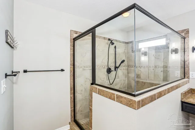 a view of a hallway with a glass door and shower