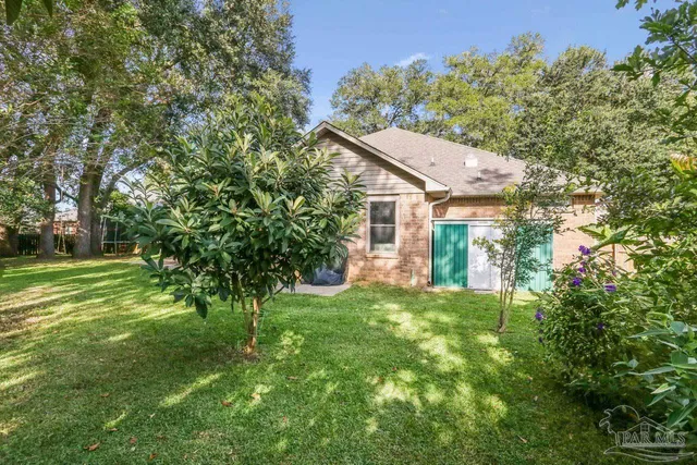 a front view of a house with a garden and trees