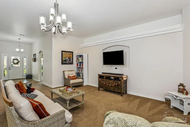 a living room with furniture a flat screen tv and kitchen view