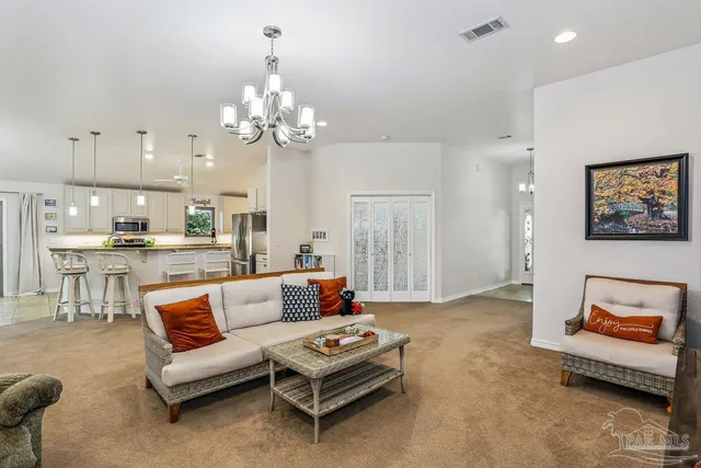 a living room with furniture and a chandelier