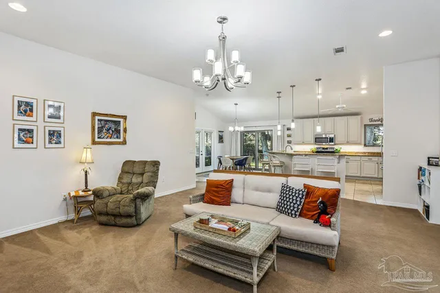 a living room with furniture kitchen view and a chandelier