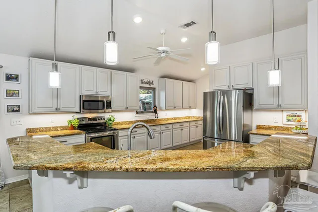 a kitchen with stainless steel appliances granite countertop a sink refrigerator and microwave