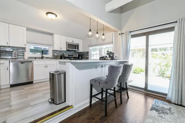 a kitchen with kitchen island a dining table chairs and wooden floor