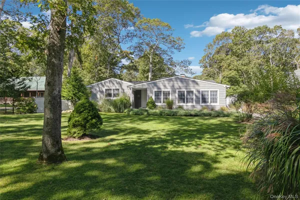 a view of a house with a big yard and large trees