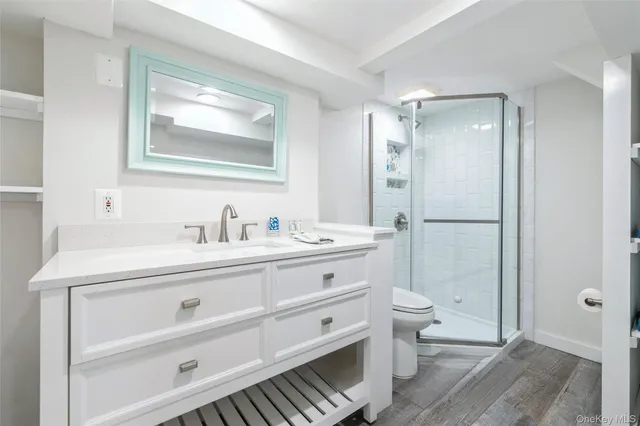 a bathroom with a double vanity sink toilet mirror and shower