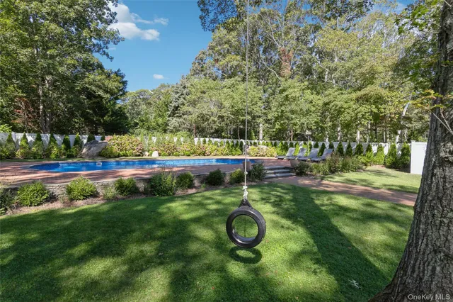 a view of yard with swimming pool and trees