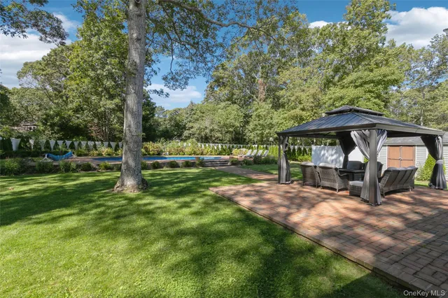 a view of a house with backyard and sitting area