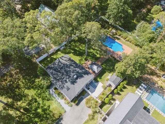 a view of swimming pool with outdoor seating and trees in the background
