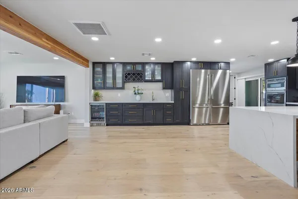 a large white kitchen with a refrigerator and a stove top oven