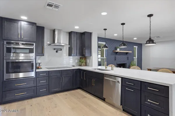 a kitchen with stainless steel appliances granite countertop a sink and wooden cabinets