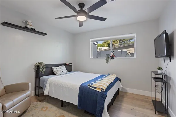 a bedroom with a bed a couch and a flat screen tv