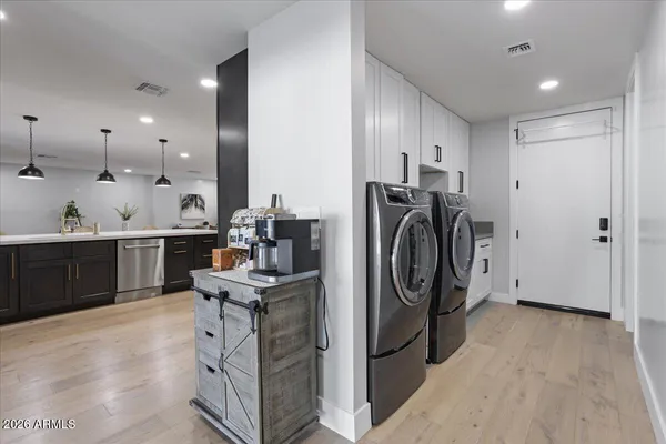 a kitchen with stainless steel appliances kitchen island granite countertop a sink a stove a washer and dryer