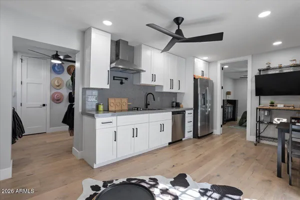 a kitchen with stainless steel appliances kitchen island a refrigerator sink and cabinets
