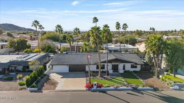 a aerial view of a house with swimming pool and mountains