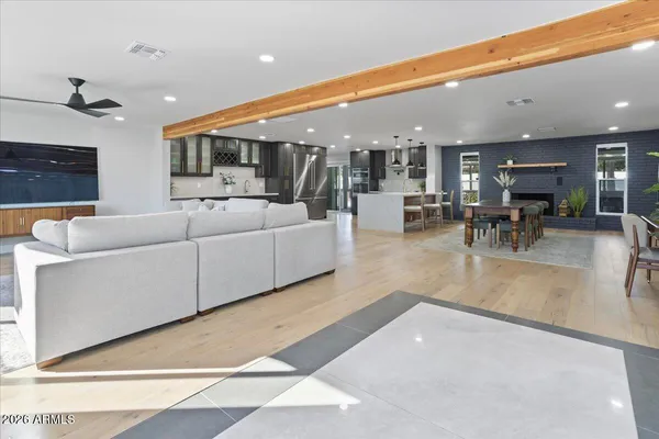 a living room with furniture a table and kitchen view