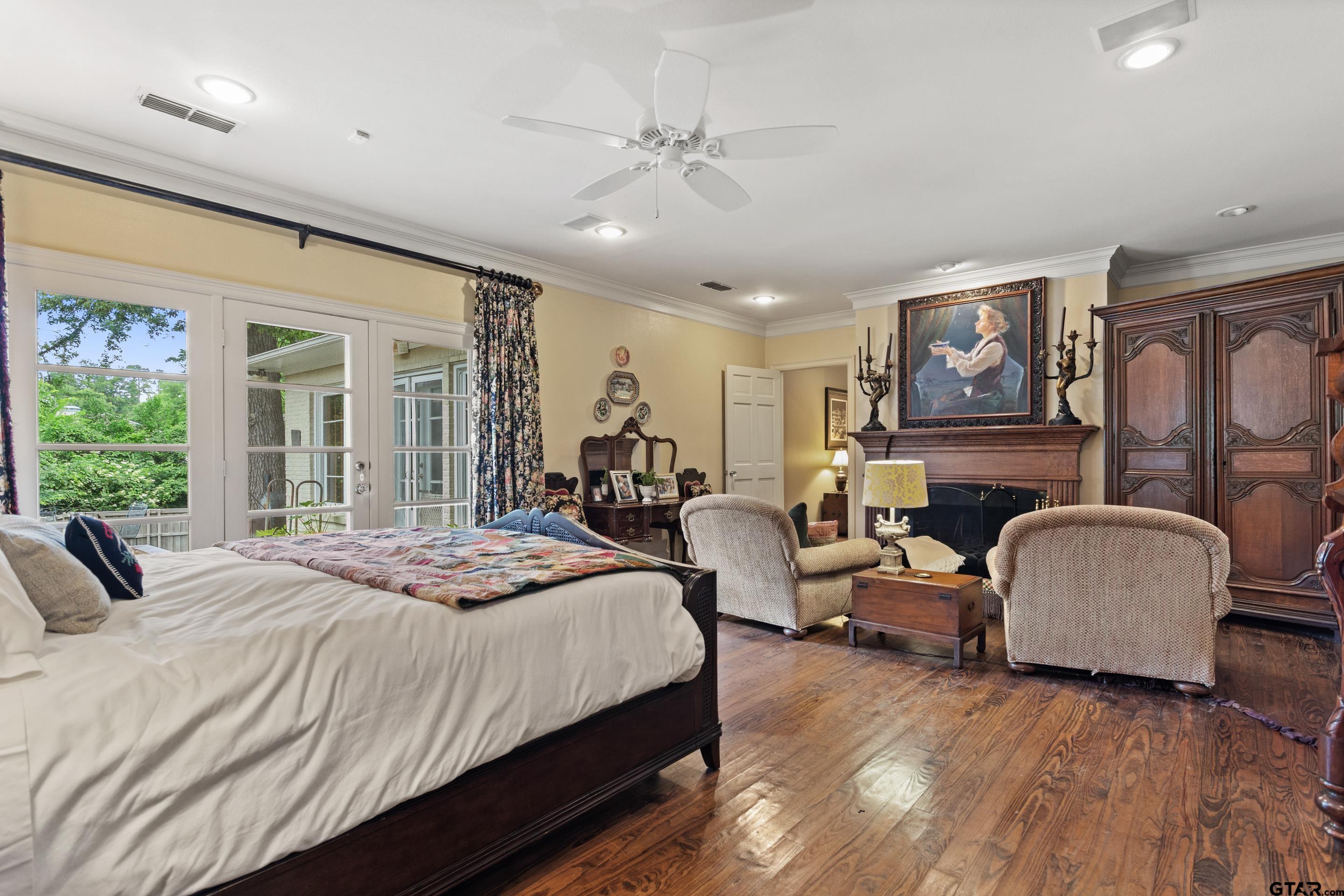 2631 Old Bullard Road Tyler, TX 75701 - Photo 19 of 43 a bedroom with a bed couches a fireplace with wooden floor
