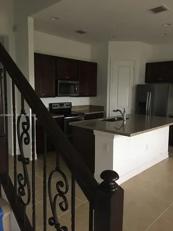 a kitchen with a refrigerator and a stove top oven
