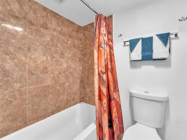 a bathroom with a toilet and a shower curtain