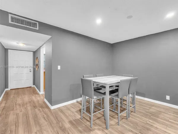 a view of a room with wooden floor white walls and table