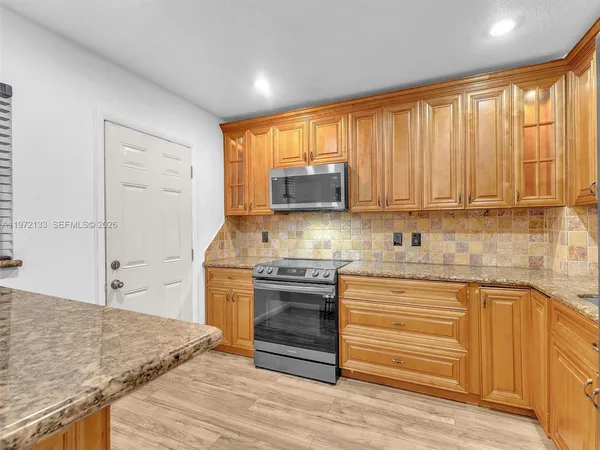 a kitchen with stainless steel appliances granite countertop a stove and cabinets
