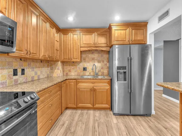 a kitchen with stainless steel appliances a refrigerator sink and cabinets