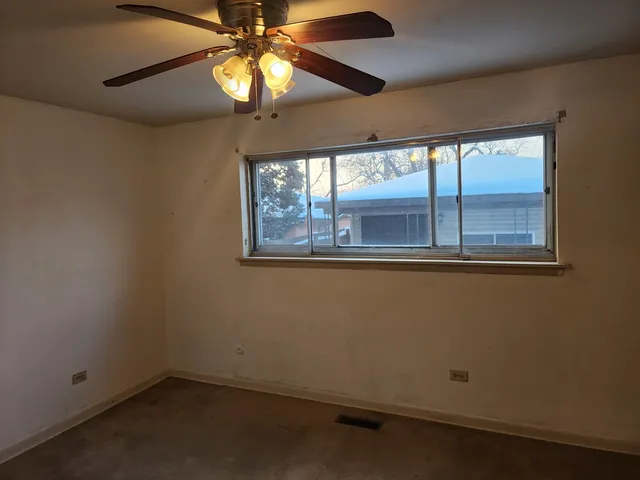 a view of house and car parked in yard