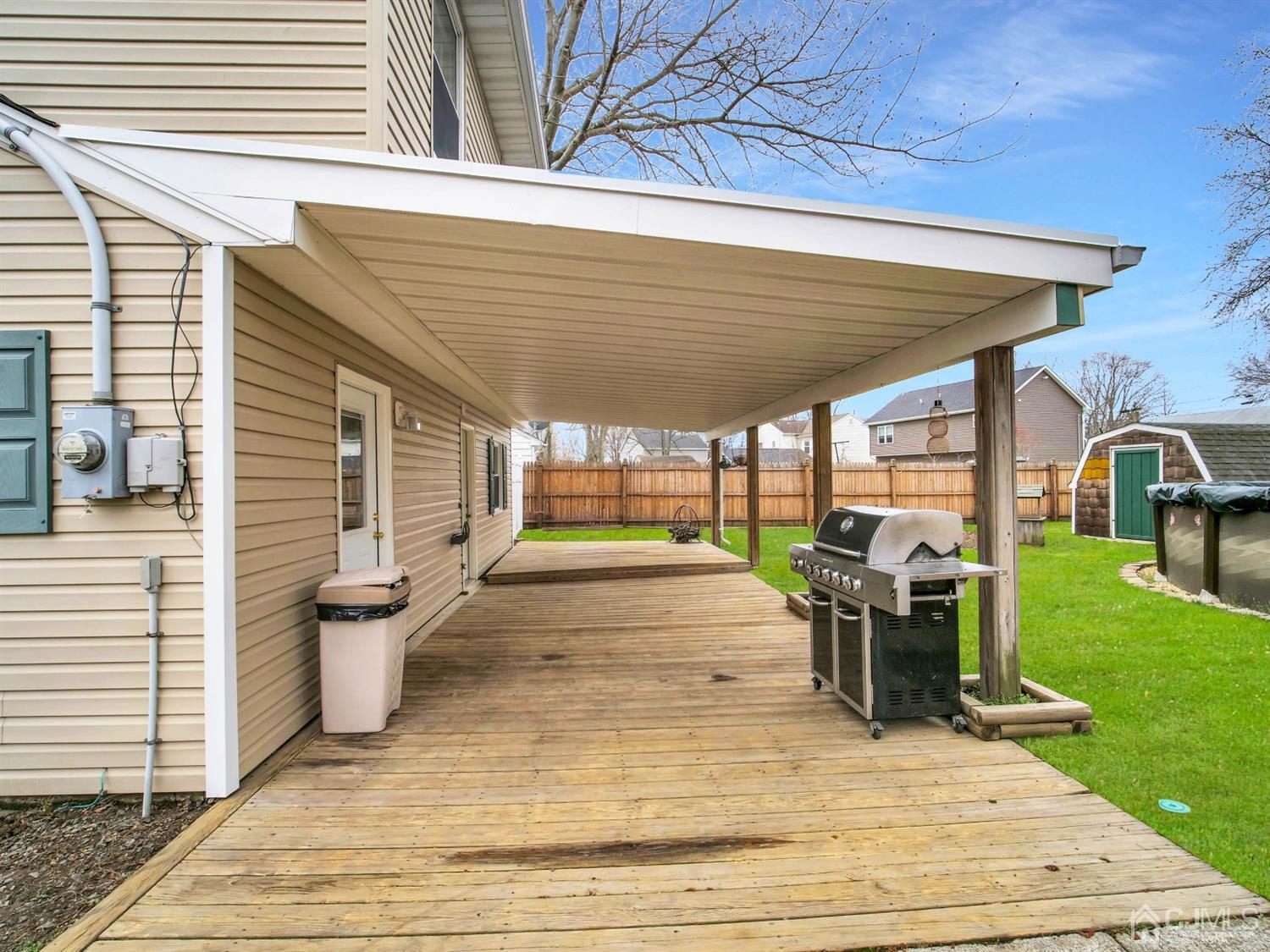 21 Crescent Road Edison, NJ 08817 - Photo 28 of 38 a view of a patio with table and chairs potted plants with wooden floor and fence