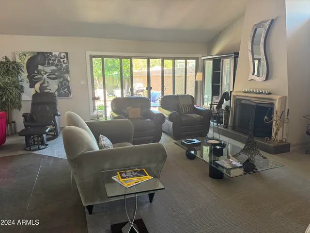 a living room with furniture a fireplace and a large window