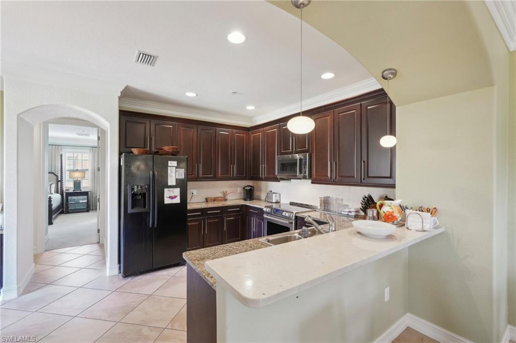 9108 Capistrano Street South, Unit 7401 Naples, FL 34113 - Photo 12 of 44 a kitchen that has a sink cabinets counter space and appliances