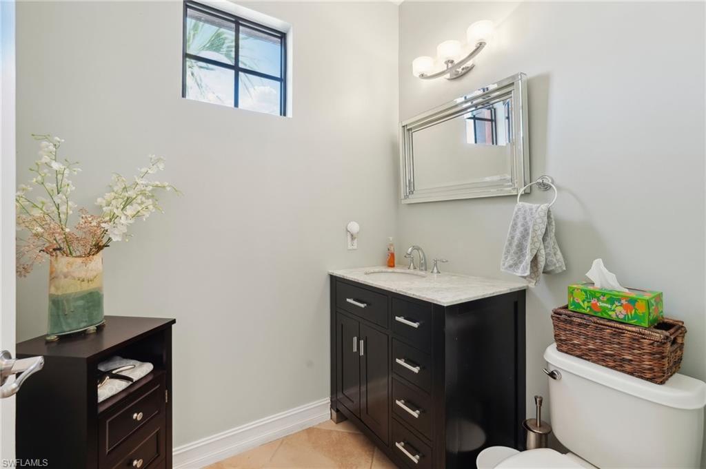 9108 Capistrano Street South, Unit 7401 Naples, FL 34113 - Photo 15 of 44 a bathroom with a sink vanity and toilet