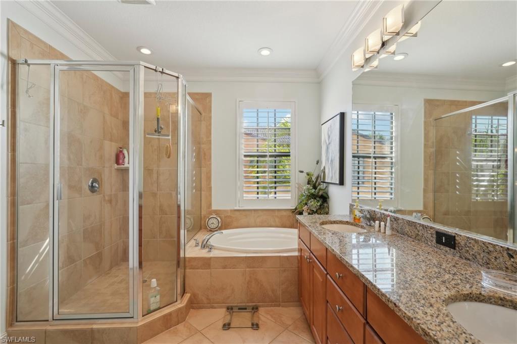 9108 Capistrano Street South, Unit 7401 Naples, FL 34113 - Photo 17 of 44 a bathroom with a granite countertop sink a large mirror and a bathtub