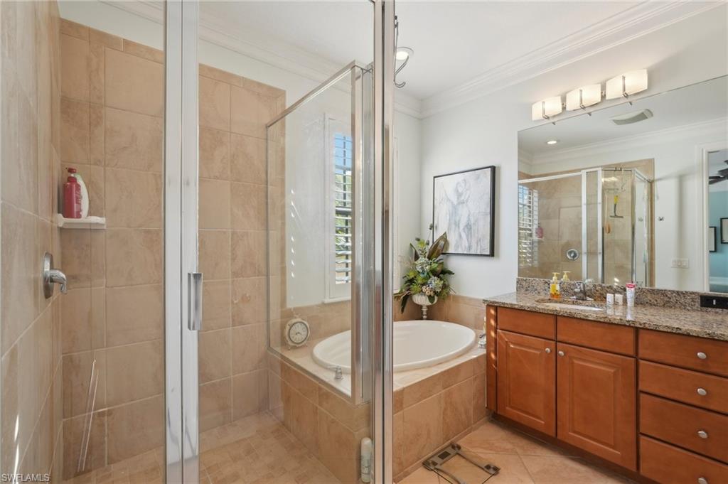 9108 Capistrano Street South, Unit 7401 Naples, FL 34113 - Photo 18 of 44 a bathroom with a tub sink shower and mirror