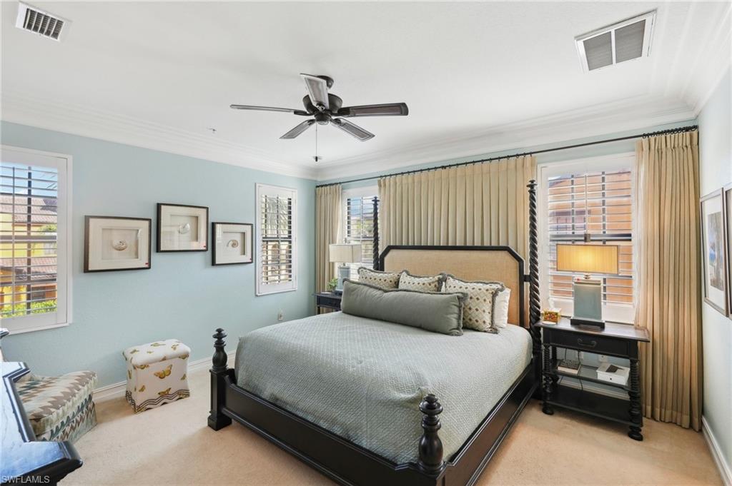 9108 Capistrano Street South, Unit 7401 Naples, FL 34113 - Photo 19 of 44 a bedroom with a bed and a chandelier