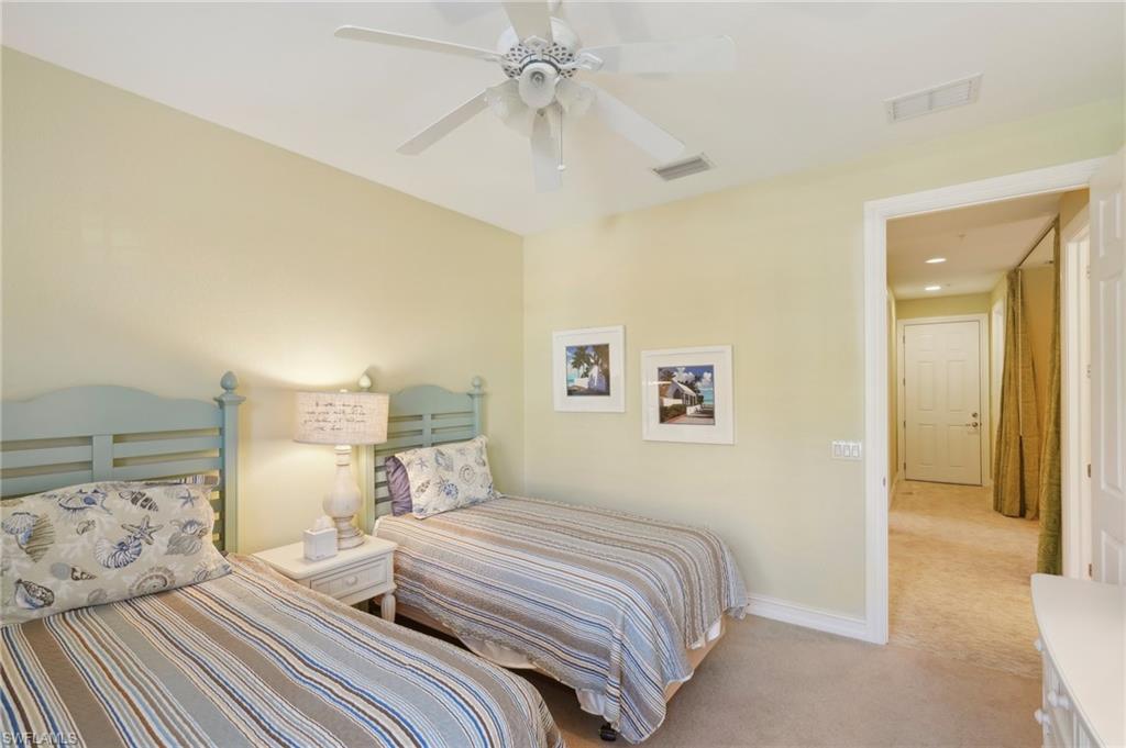 9108 Capistrano Street South, Unit 7401 Naples, FL 34113 - Photo 23 of 44 a bedroom with a bed and a chandelier