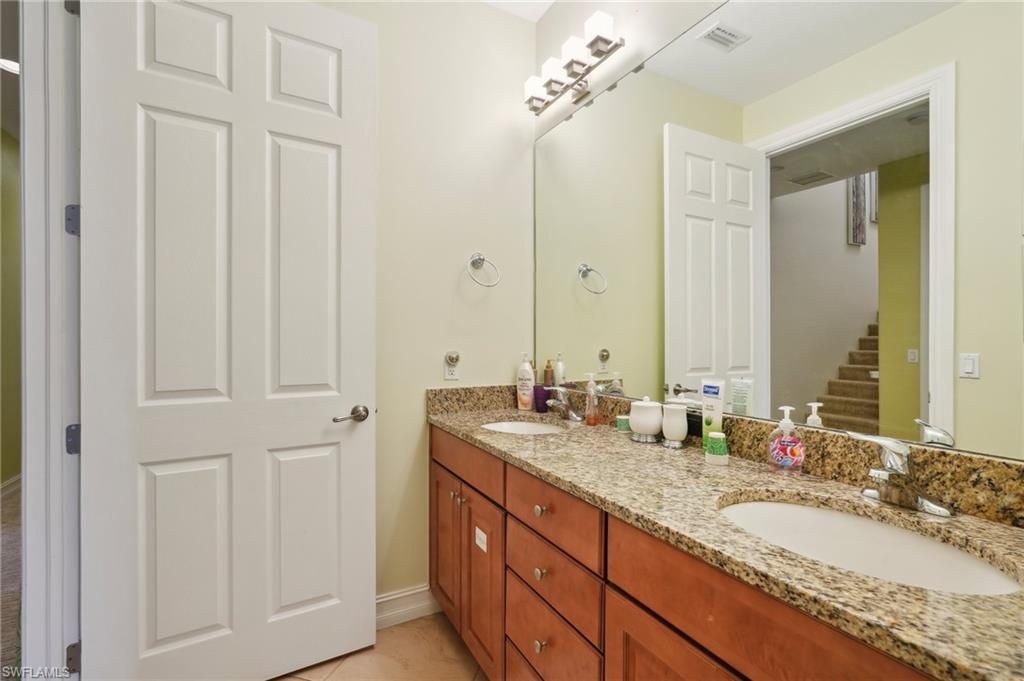 9108 Capistrano Street South, Unit 7401 Naples, FL 34113 - Photo 25 of 44 a bathroom with double sink and a mirror
