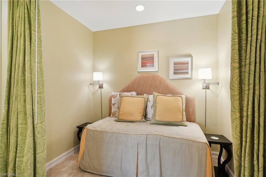9108 Capistrano Street South, Unit 7401 Naples, FL 34113 - Photo 26 of 44 a bedroom with a bed and a night stand